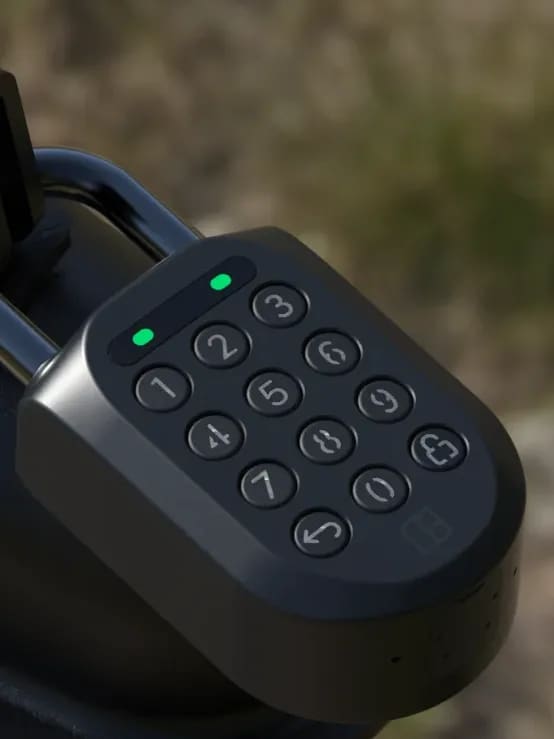 The keypad padlock fitted to a field gate, its two green lights showing